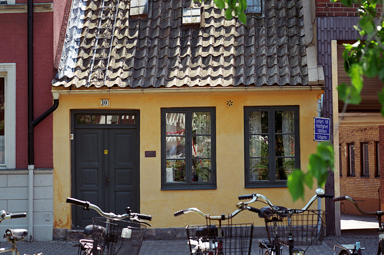 Fotografi på fasaden till Ebbas Hus. Huset är gult och fönster och dörrar är gröna.
