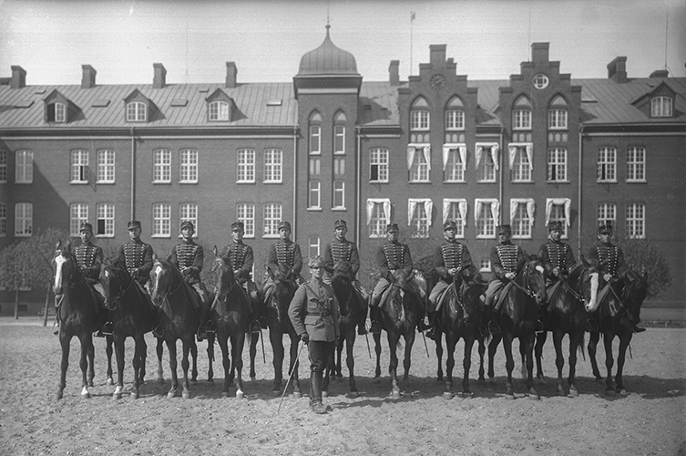 Fotografi på ett flertal uniformerade män på hästar. 
