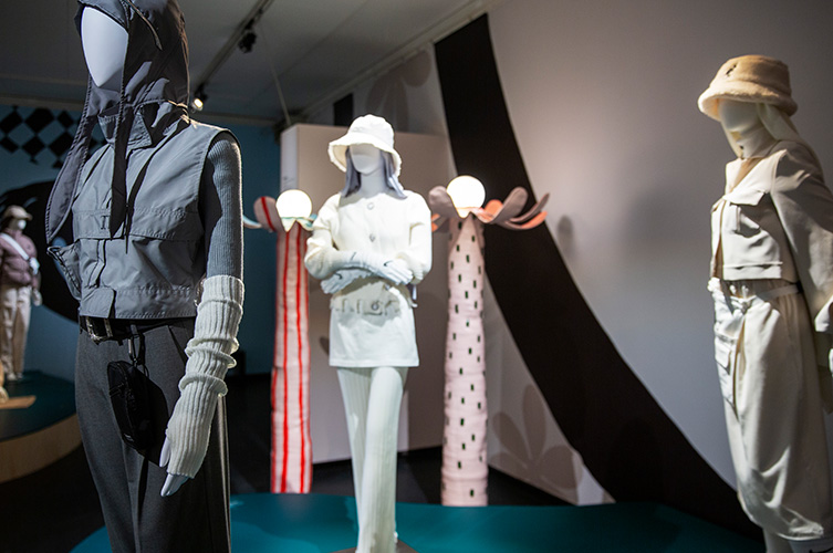 BIldspel från utställningshallen. Plaggen visas på dockor i naturlig storlek, några fritt på små podier och andra i glasmontrar. 