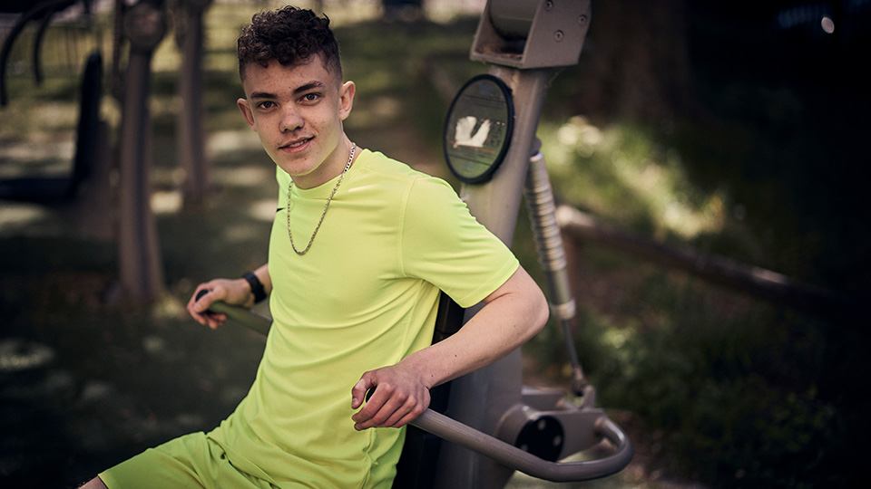 En elev i gula träningskläder tränar i skolans utegym. 