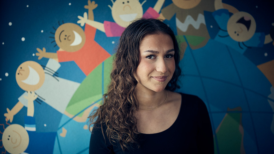 En elev på barn- och fritidsprogrammet tittar rakt in kameran och ler. 