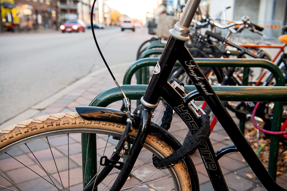 Nytaget fotografi. Närbild på cyklar i cykelställ.