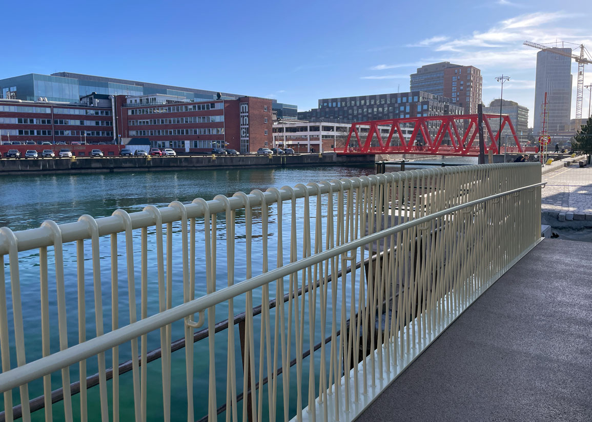 Dockportsbrons smörgula räcke mot Södra varvsbassängen, med Beijers bro i bakgrunden.