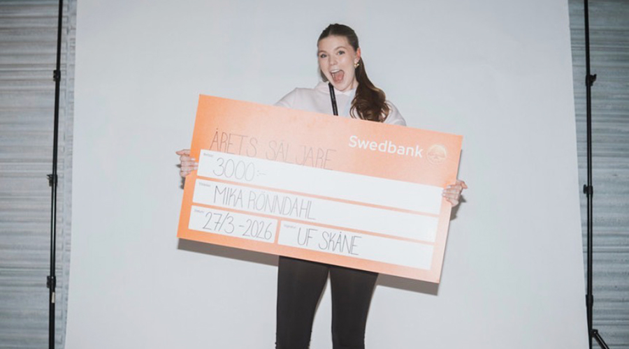 Mika Rönndahl framför en fondvägg med sitt pris.