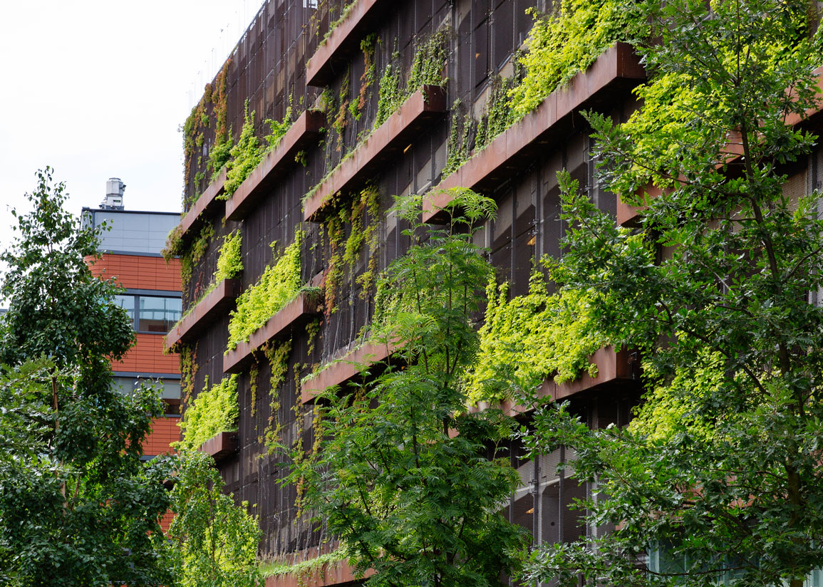 Fasad på parkeringshus med gröna klätterväxter.