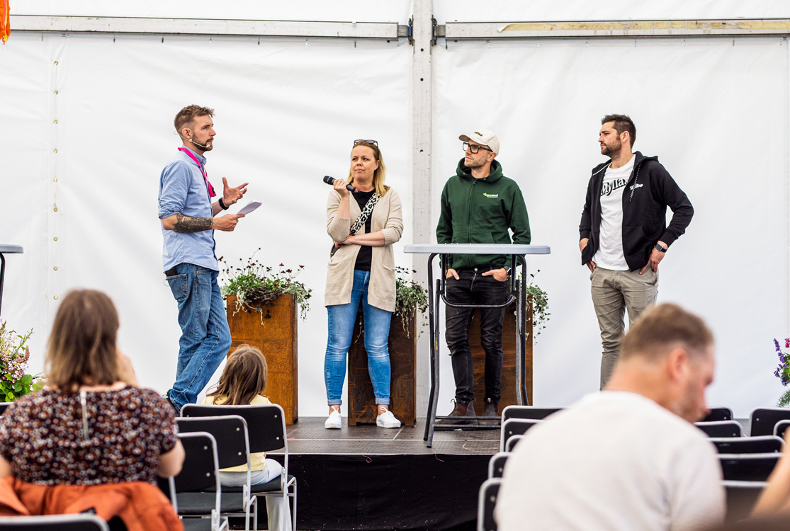 Fyra personer står på en scen och talar inför publik.