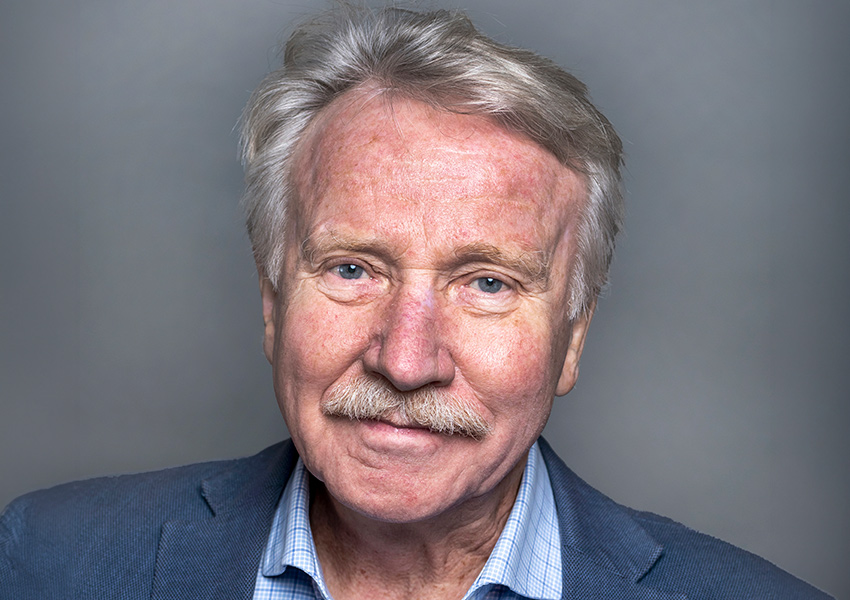 Ilmar Reepalu har ljusgrått hår och mustasch och är klädd blå kostym med ljusblå skjorta. 