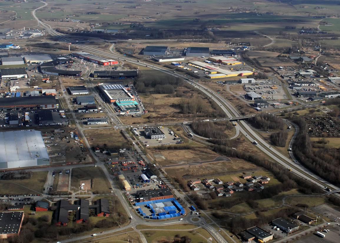 Flygvy över Valdemarsro verksamhetsområde vid motorvägen,  med industribyggnader och ledig mark i Mosippan