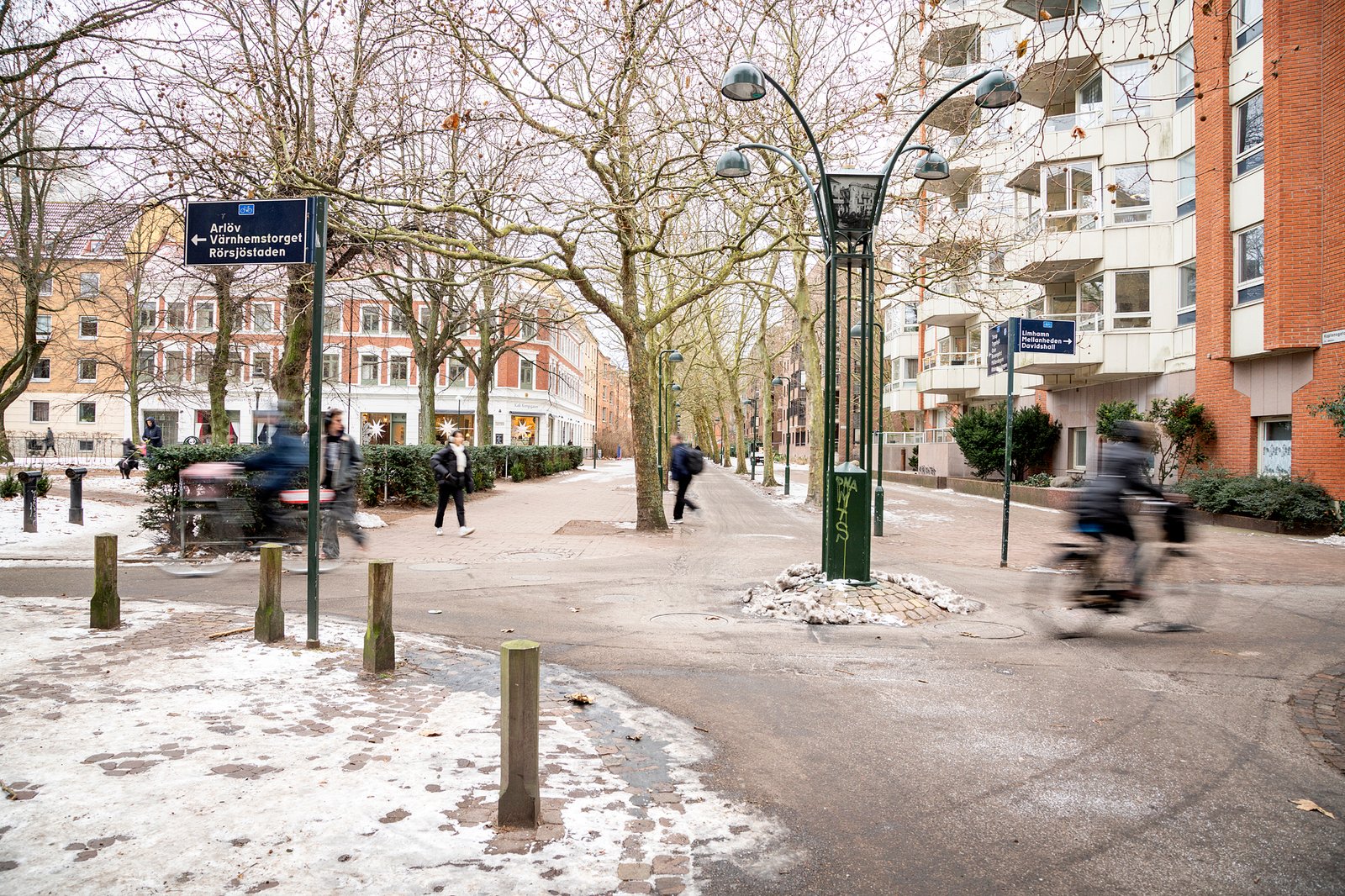 Korsningen mellan Kaptensgatan och Kungsgatan med cyklister och en pelare i mitten.