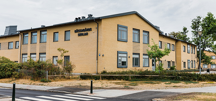 Bäckagårdsskolan är en gul tegelbyggnad med många fönster för bra ljusinsläpp.