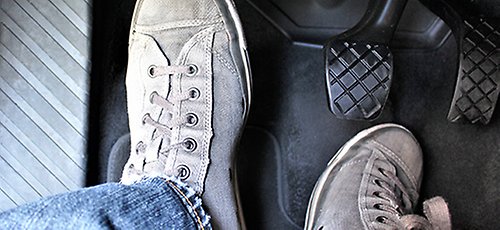 Elev testar avståndet till bilens pedaler innan övningskörning.