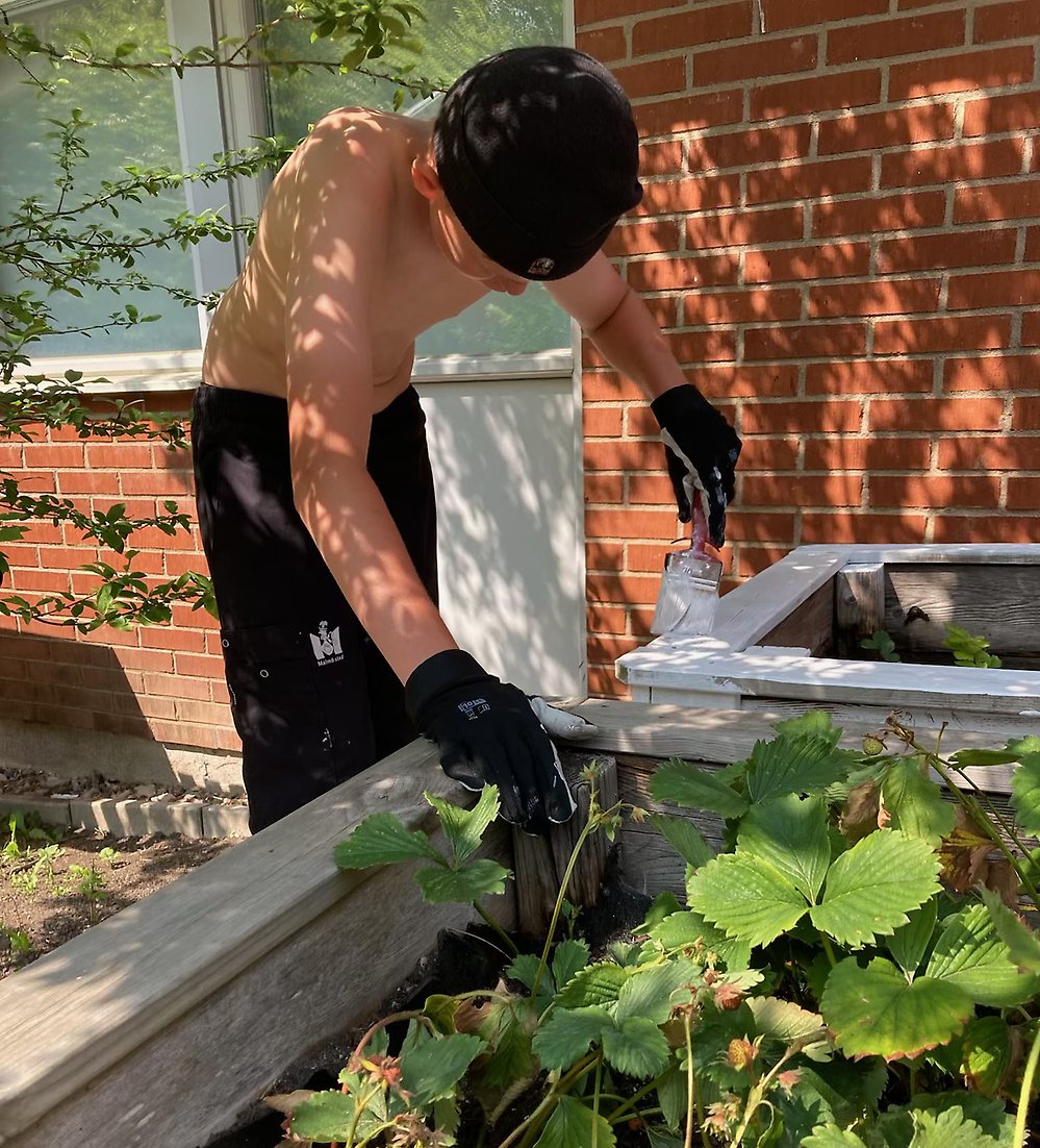 Leo målar om pallkragarna på ett boende