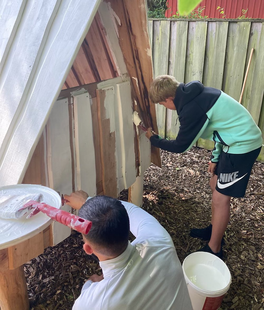 Leo och hans kontaktperson Mostafa målar panelen i vitt