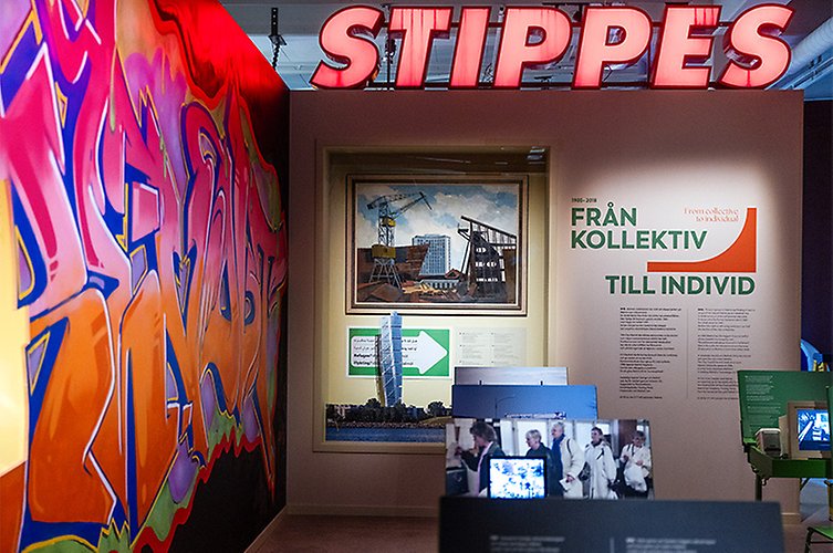Del av utställningen, stor fasadskylt "Stippes", en grafittivägg, foto med Malmömotiv och informationstext på väggen.