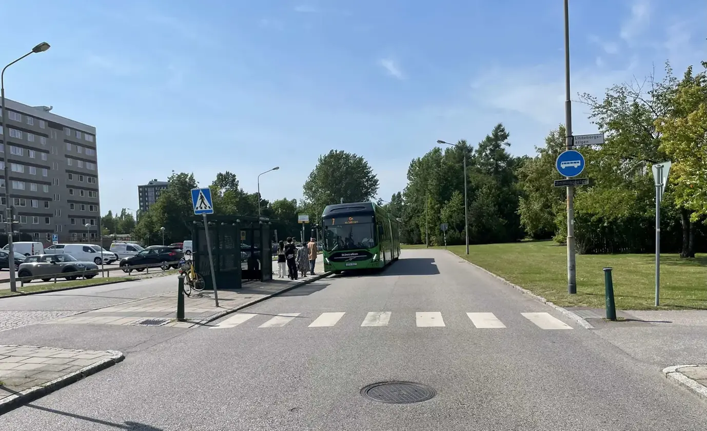 Stadsbuss vid hållplats i Lindeborg C en solig dag.