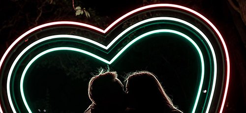 Ett par som pussas under ett ljushjärta i Malmö. 