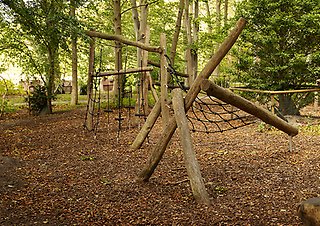 Klätterställning gjort av stora stockar, träd i bakgrunden