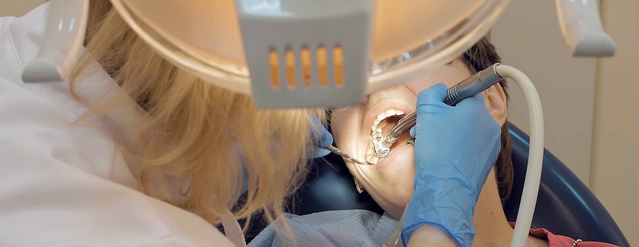 Tandläkare med patient i tandläkarstol