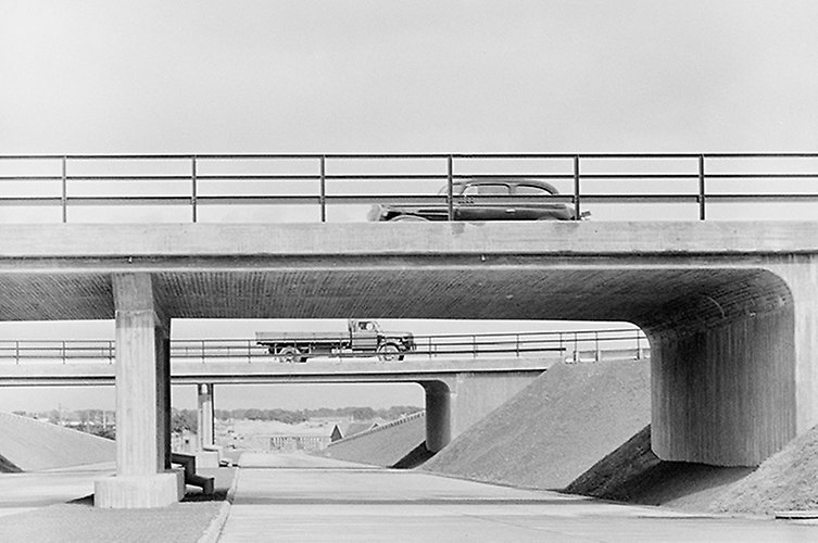 Svartvitt foto av motorväg med två broar över.