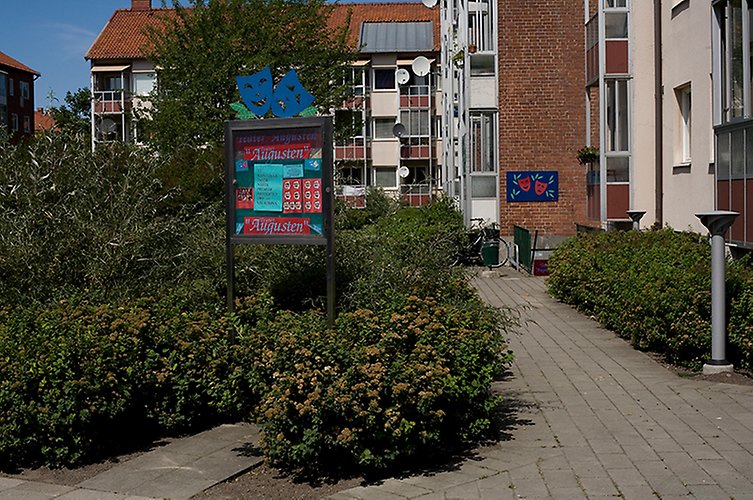 Del av en gård intill ett bostadshus i rött tegel.