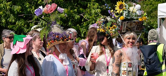 Några kvinnor med fantasifulla blomsterkreationer på huvudet. 