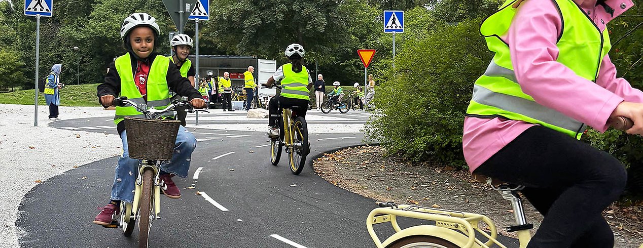 Barn i gula västar som cyklar.