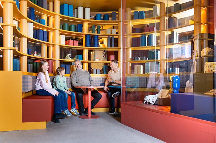 Mitt i utställningen finns flera sittplatser, bland annat en rund soffa.