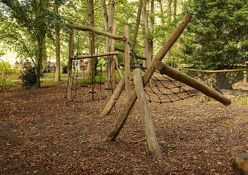 Klätterställningar i bland träd i anslutning till den nya lekplatsen