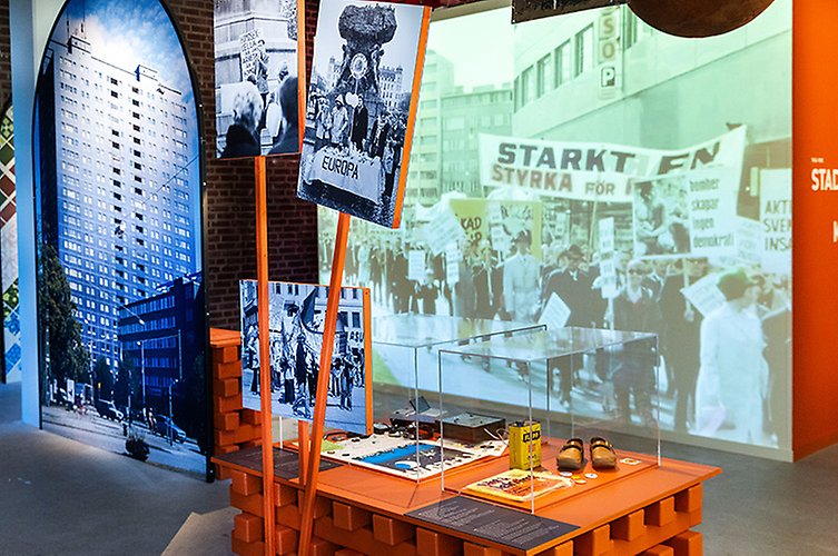 På en av väggarna i utställningen visas ett collage av filmer från Malmö genom tiderna på en stor väggskärm. 