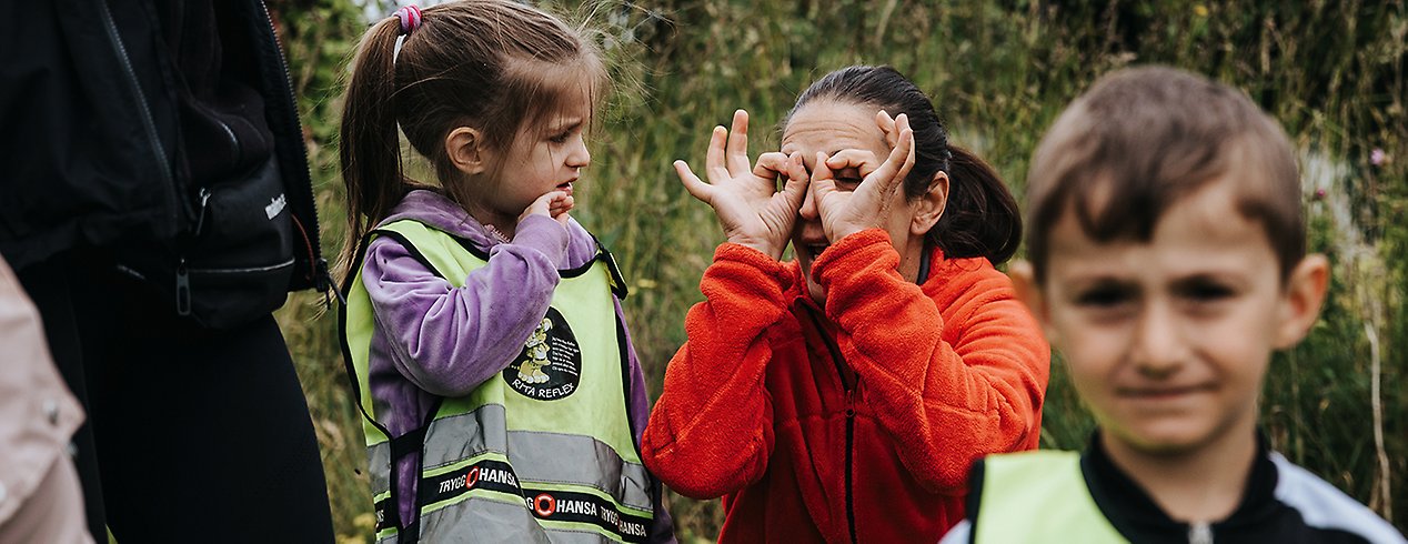 Mila, 4 år, Karolina Kmieciak, förskollärare, och Bledi, 4 år, utforskar Bokträdgården utanför Torup.