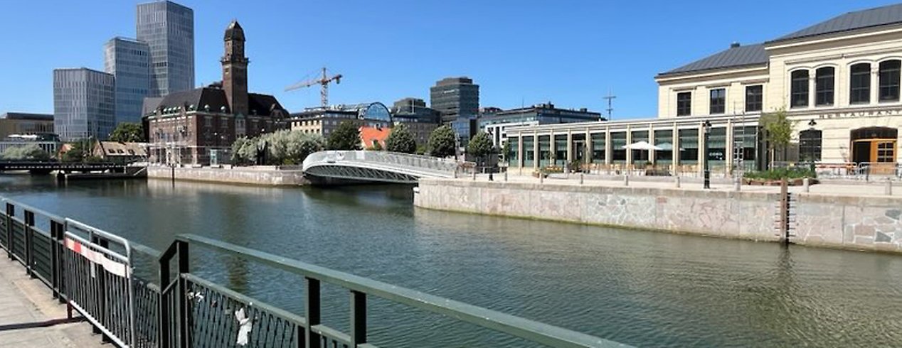 En kanal med en kaj och ett äldre hus som är placerad längs med kajen.