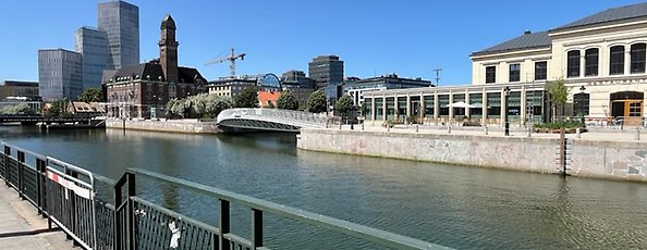En kanal med en kaj och ett äldre hus som är placerad längs med kajen.
