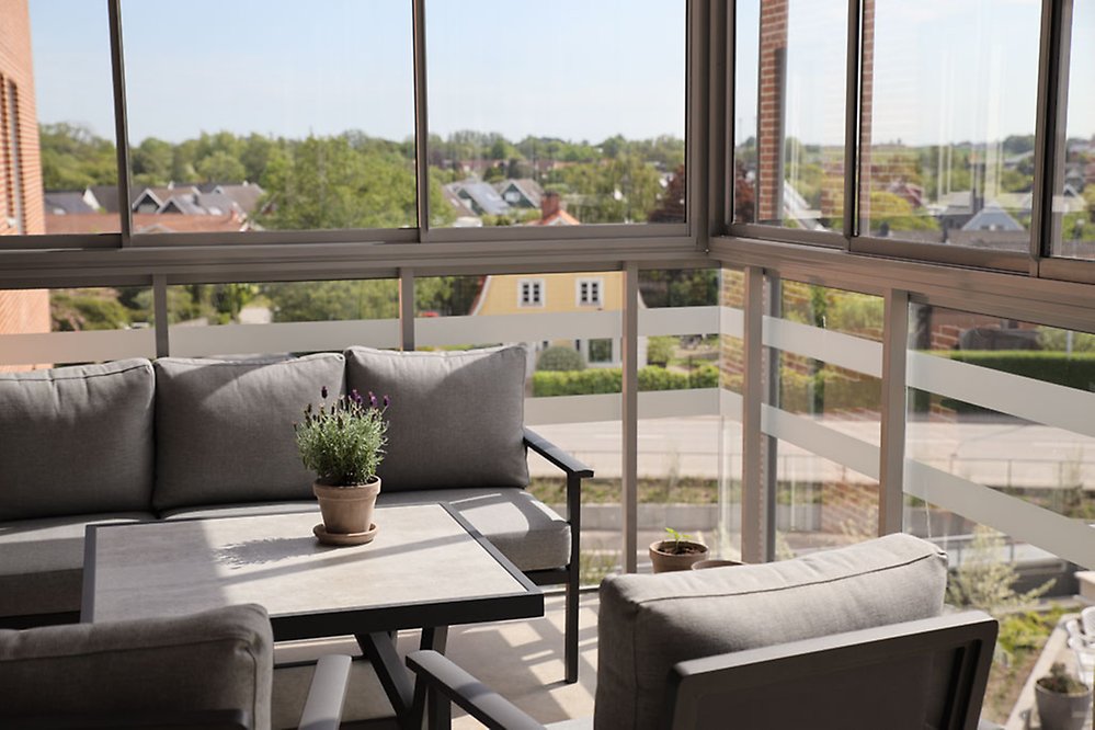 På de inglasade balkongerna kan man sitta och njuta
i soffgrupper och blicka ut över hus och åkrar.