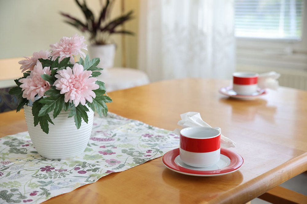 Blombukett i vas ger ett hemtrevligt intryck när det är dags
för kaffe.