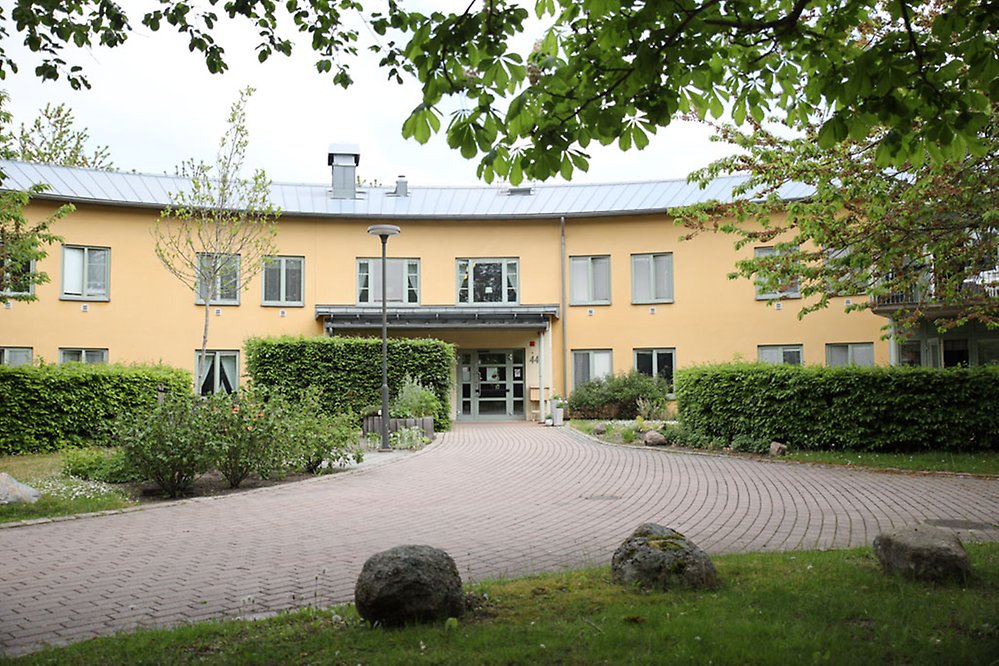 En stensatt gång leder fram till den gula tvåvåningsbyggnaden med
ljusgröna detaljer.