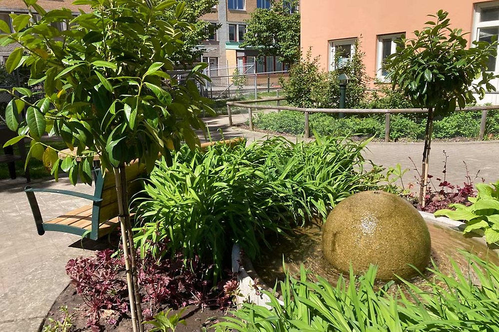 På innergården omringas den porlande fontänen av växter och träd.