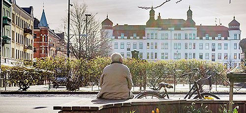 En man sitter och tittar ut över Möllevångstorget. 