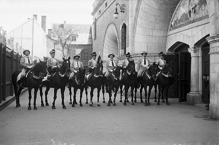 Åtta personer till häst poserar utanför Hippodromen. 