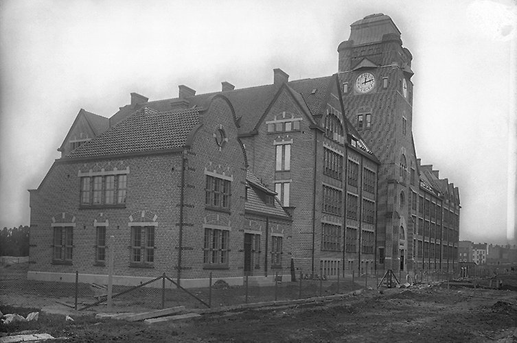 Äldre svartvitt suddigt foto av byggnaden som fortfarande ser ut som en byggarbetsplats. Inga andra byggnader syns runtom.