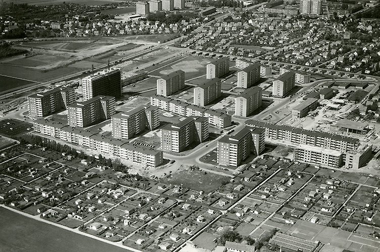 Svarttvitt flygfoto med låg och hög bebyggelse