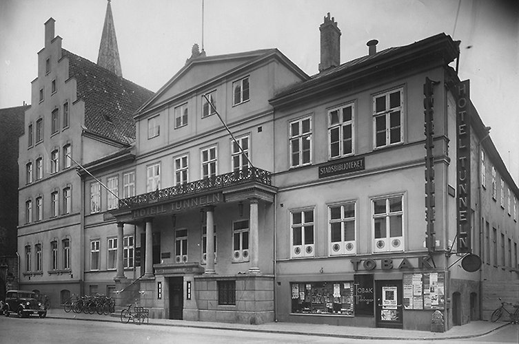 Två hus i rad, Gata med äldre bil i förgrunden.