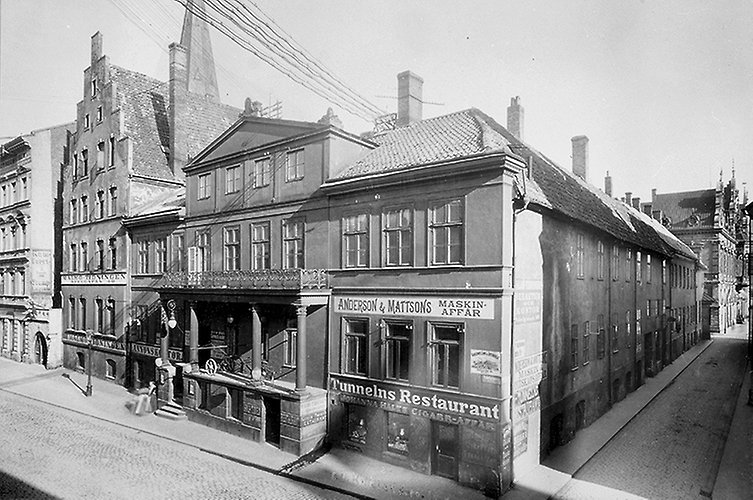 Fyra hus i rad, gator på två sidor.