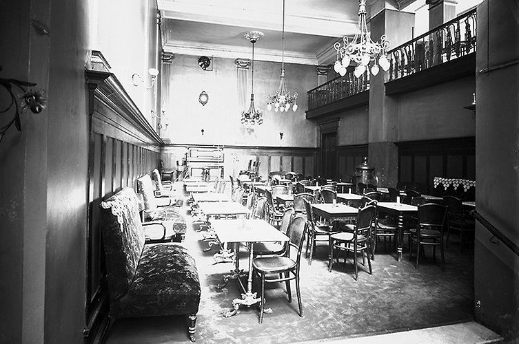 Soffor, stolar och bord i gammal stil. Väggarna har halvpanel i trä.