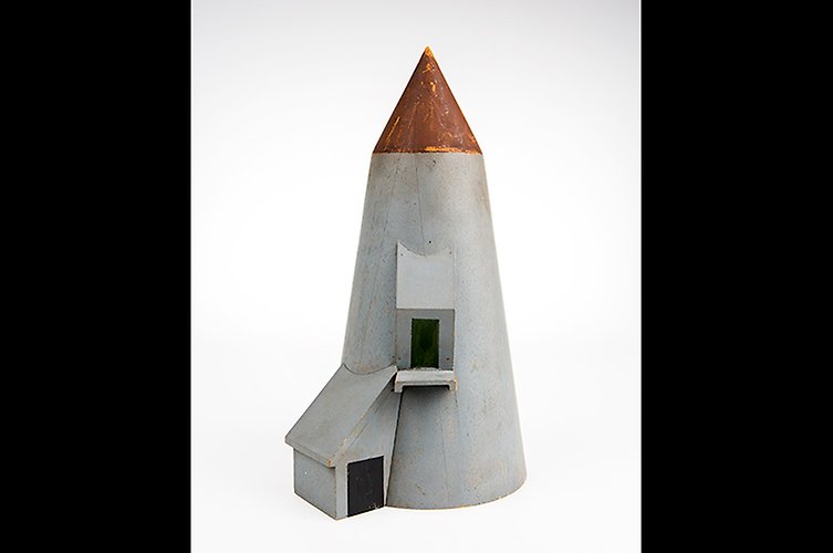 Modell av annorlunda byggnad med spetsigt tak. 