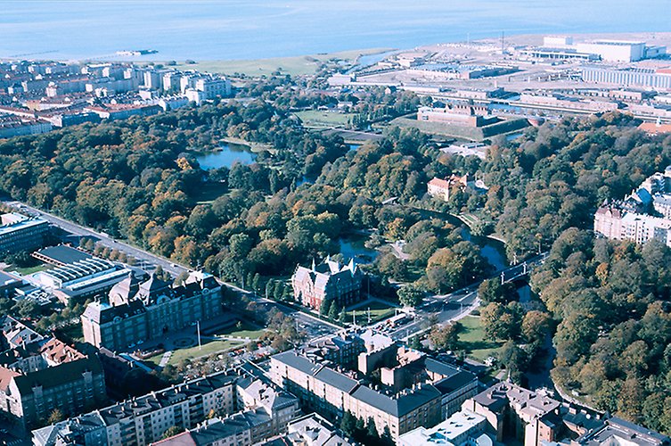 Flygfoto med fokus på parkområde med omgivande stadsmiljö.