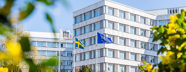Malmö stads stadshus. Utanför står tre flaggstänger med en Malmö stad flagga, en Sverigeflagga och en EU-flagga.