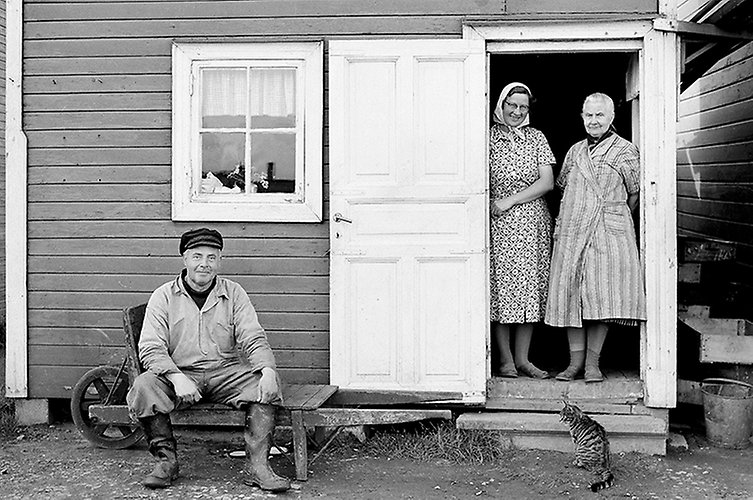 Bild från kvarteret Abborren 1955. På bilden syns en fiskare och två kvinnor vid en bod vid sillabåtarna. 