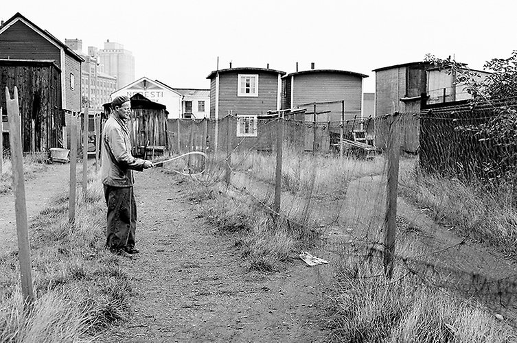Bild från kvarteret Abborren år 1955. På bilden sysn en man framför sillabodarna. 