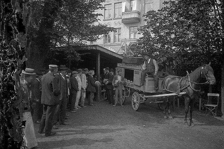 Folk i kö och hästvagn.