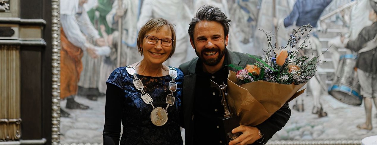 Anton Dahlberg, OS-medaljör i segling, och Carina
     Nilsson, kommunfullmäktiges ordförande, håller om varandra framför kameran. 